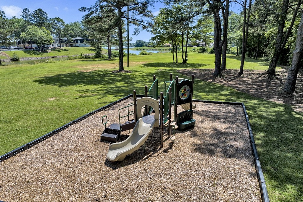 A playground with a slide and a green sign.